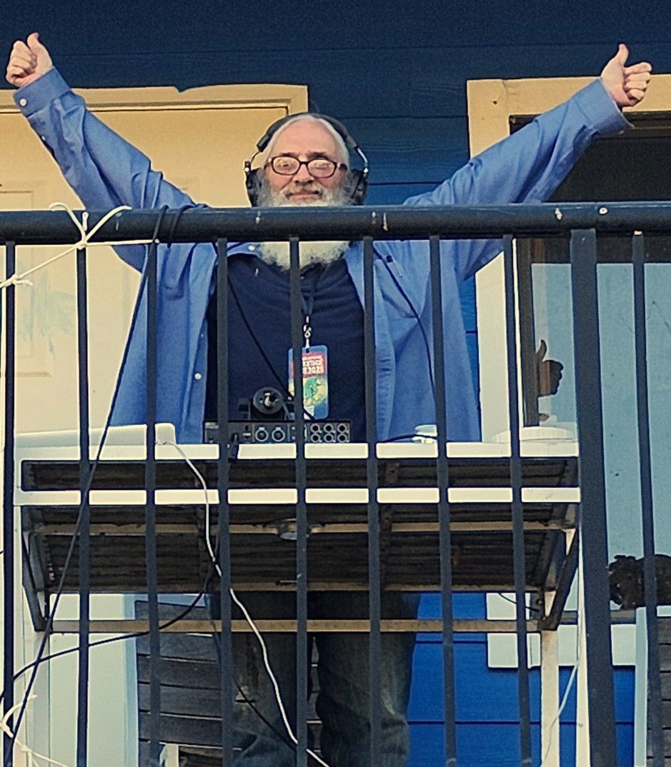 Photo of George Dupuis wearing headphones on a balcony