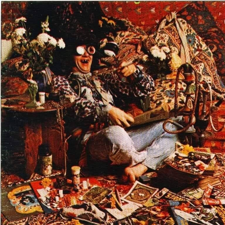 A smiling man surrounded by bright kitsch.