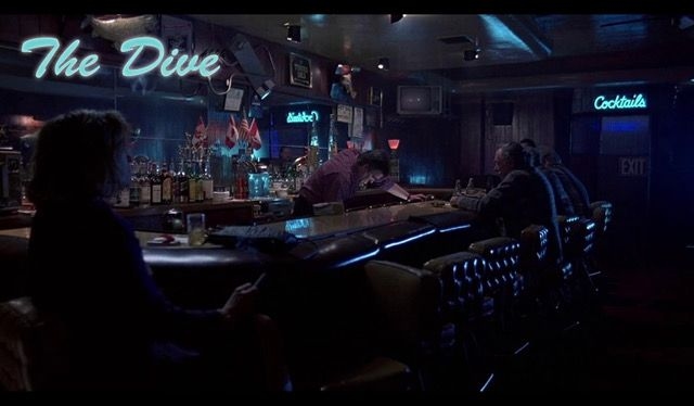 Blue neon illuminates a dark bar room.