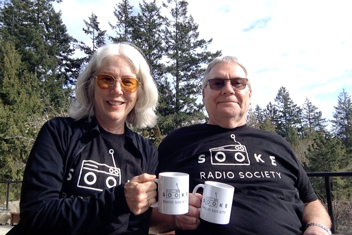 The hosts of Aroundabout Sooke toasting with their Sooke Radio Society Mugs
